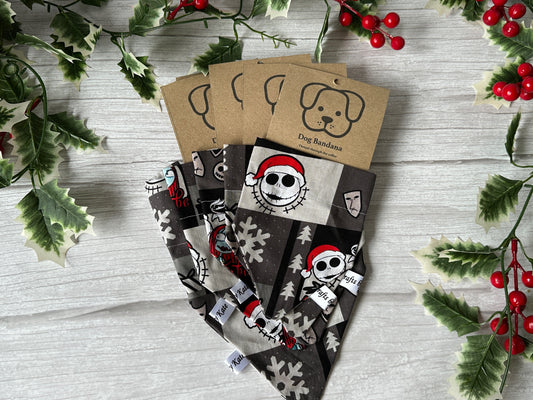 Four handcrafted Crafts by Kate Cotton Pet Bandanas with collar attachment, featuring Jack Skeleton’s Christmas cartoon faces and snowflakes. Each comes with a brown “Dog Bandana” label showing a dog’s face, holly, and berries on light wood.