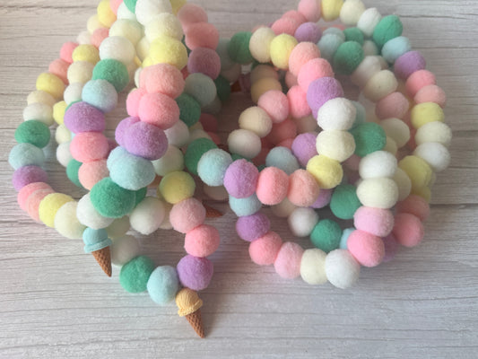 The PomPom Pet Collar - Fresh as a Daisy by Crafts by Kate features colorful pastel pom-pom beads and small, ice-cream-cone-shaped accents, handcrafted and coiled for a playful look on your pet.