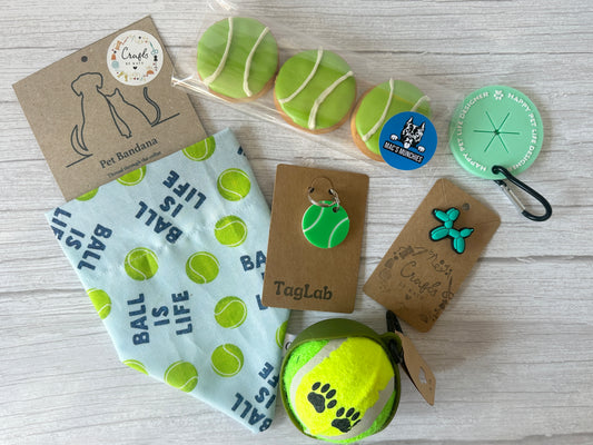 The Crafts by Kate Custom Order - Personalised Ball is Life Box includes pet-themed items: a personalised bandana, tennis ball cookies, a tennis ball, scrunchie keychains, mint waste bag holder, blue dog sticker, and tags.